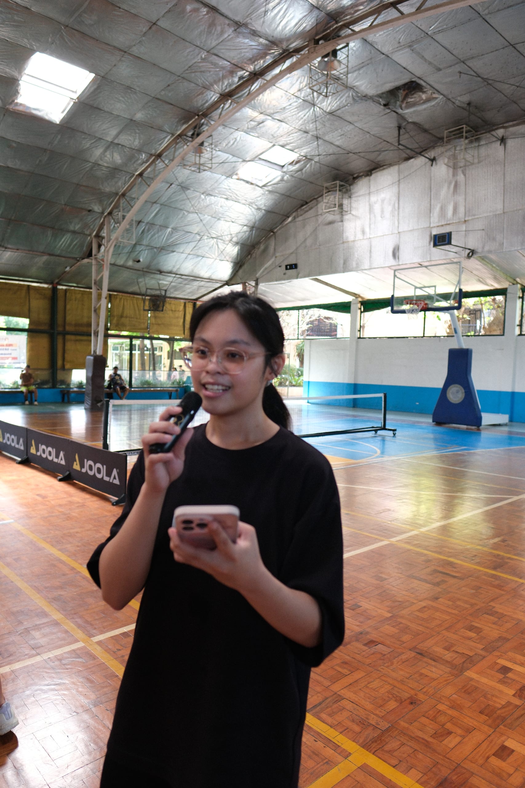 A participant speaking into a microphone on the court
