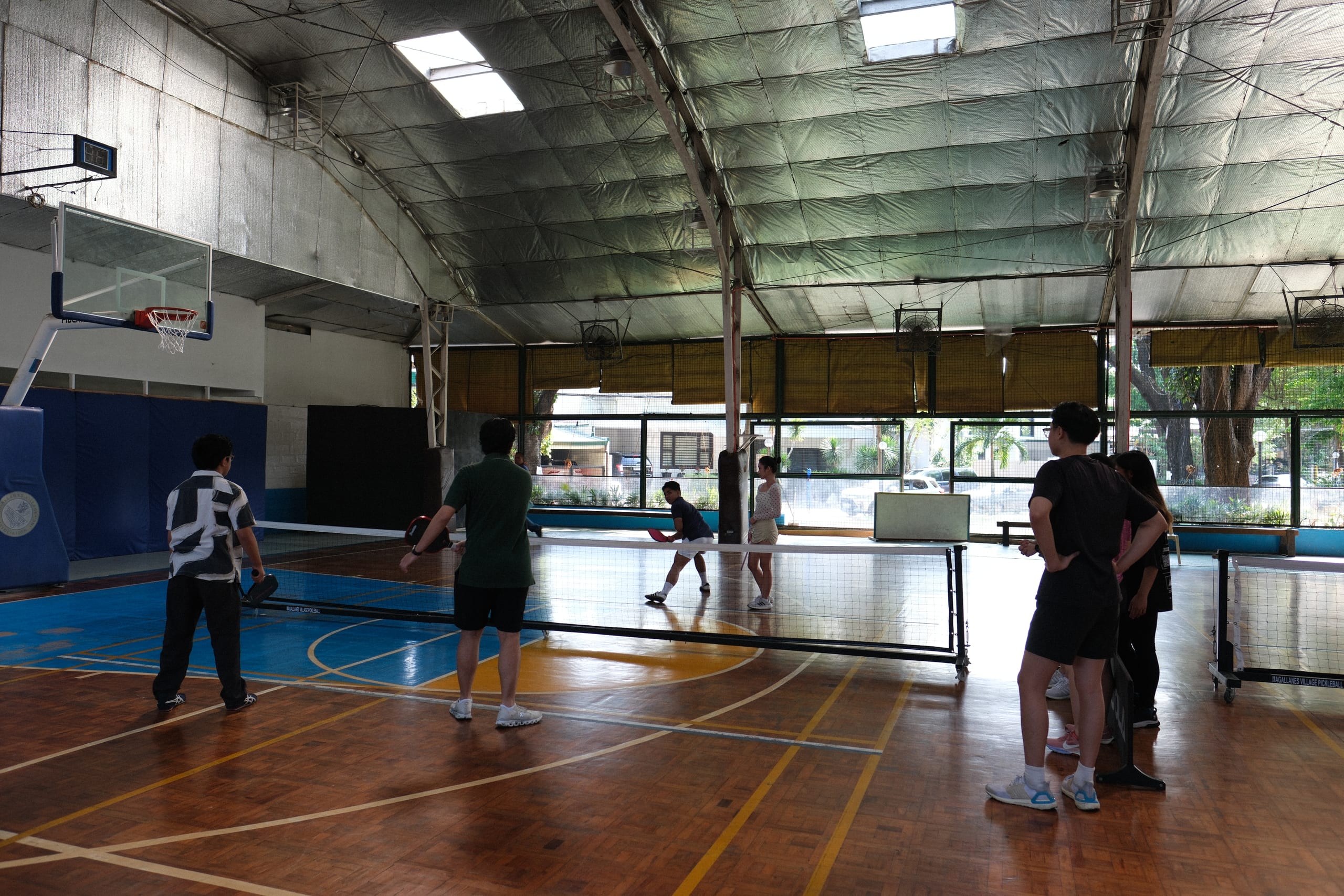 Players watching a pickleball rally across the net